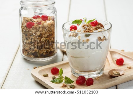 Homemade yogurt or sour cream in a glass on the white wooden table