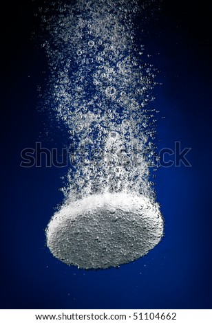 Effervescent tablet in water with bubbles...