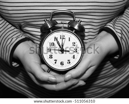 alarm clock in female hands

