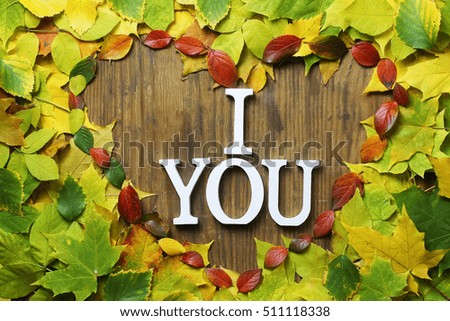 autumn leaves background in shape of heart on wooden table