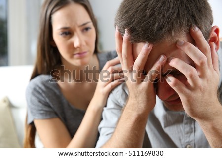 Sad man and a friend or girlfriend trying to console him at home. Friendship concept Royalty-Free Stock Photo #511169830