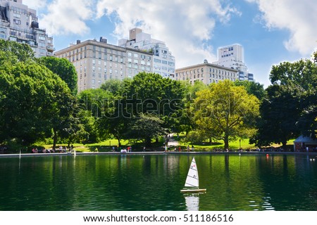 Summer day in Central Park, New York with toy boat on lake