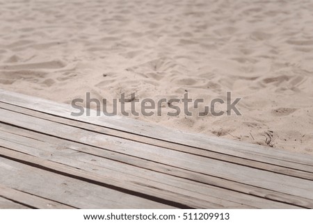 Top view of wooden beach boardwalk with sand texture background