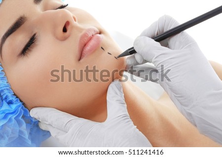 Plastic surgery concept. Hands in gloves marking women face Royalty-Free Stock Photo #511241416