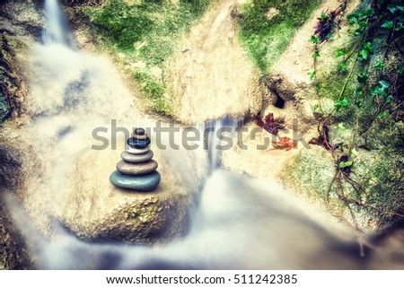 Balanced Rock Zen Stack in front of waterfall.