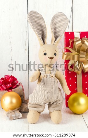 toy rabbit and gift boxes on a wooden background