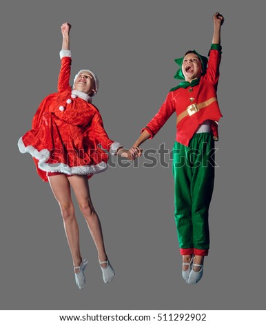 Jumping funny kids in Peter pan and snow maiden costume isolated on grey background.