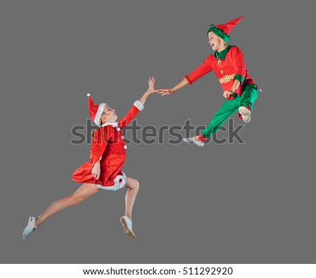 Jumping funny kids in Peter pan and snow maiden costume isolated on grey background.