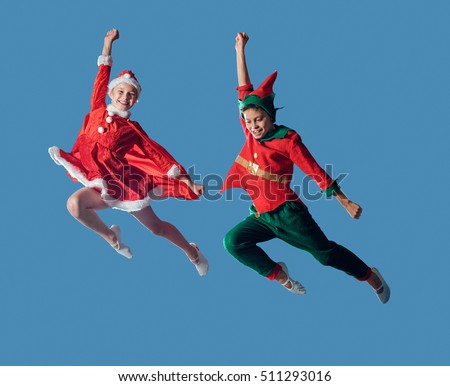 Jumping and flying funny kids in Peter pan and snow maiden costume isolated on blue background.