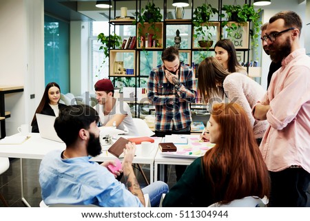 Team of young business professionals using technology in an informal meeting engaged on architect design. International students learning together in university library. Concept of successful startup Royalty-Free Stock Photo #511304944