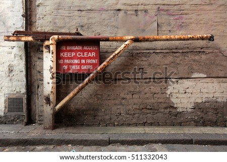 Old rusted barrier with a KEEP CLEAR sign and information that this road will be used for evacuation in an emergency, London