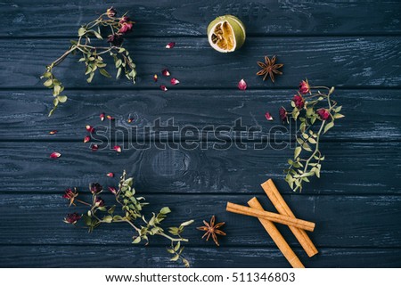 Autumn or winter composition of dried flowers and spices on wooden background. Top view, flat lay, copy space.