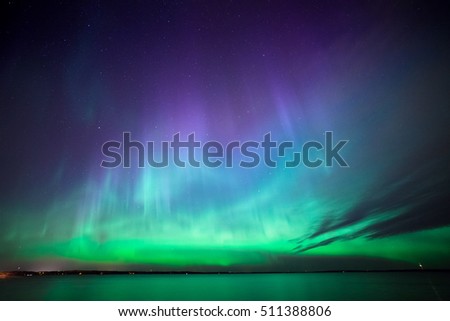 Beautiful northern lights aurora borealis over lake in finland Royalty-Free Stock Photo #511388806
