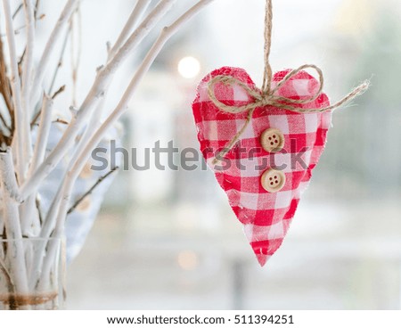 Valentine's Day Wallpaper. Handmade heart Christmas decoration hands on a wooden branch on defocused background copyspace. Christmas wallpaper. Valentine's Day postcard.