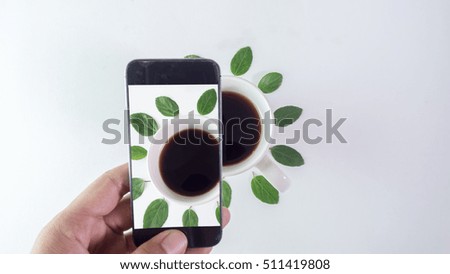 smart phone photograph green leaves around cup coffee frame on white background