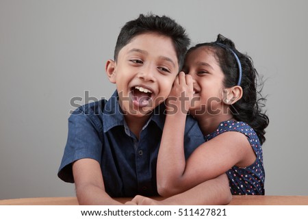Little girl tells a secret to the boy Royalty-Free Stock Photo #511427821