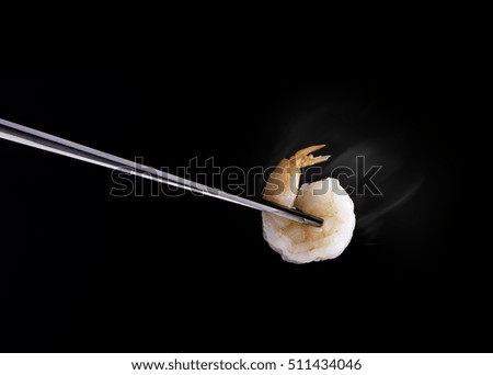 Shrimp with shop stick. Hot shrimp and copy space on black background.