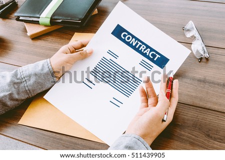 Businessman signing contract on wooden table