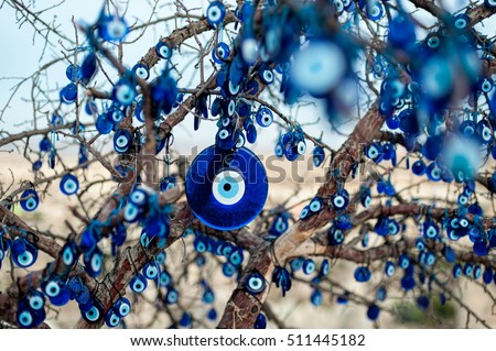 The branches of the old tree decorated with the eye-shaped amulets - Nazars, made of blue glass and believed to protect against the evil eye in Goreme national park, Cappadocia, Turkey.