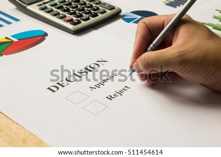 Businessman hold pen for approve and reject decision with calculator and financial graph support