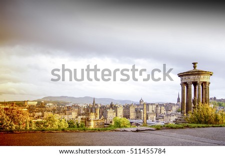 Edinburgh, Scotland cityscape, on a cloudy sunset. View from the Calton Hill, with Edinburgh castle in the background and Dugald Stewart Monument in the front. Artistic surreal edit.