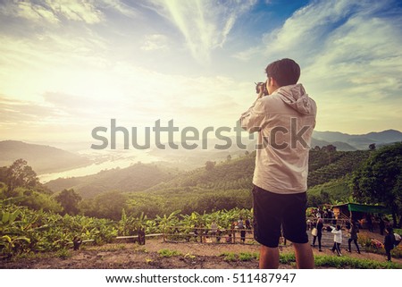 Man taking photo of beautiful mountain landscape.