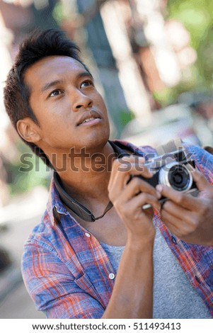 Young man taking picture in NYC neighborhood