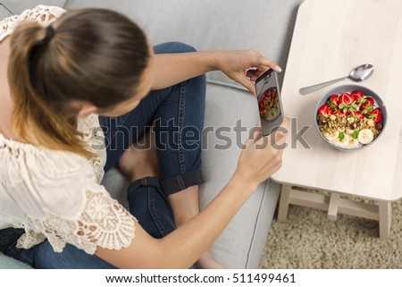 Woman sitting on the couch ready to eat and talking picture to her food