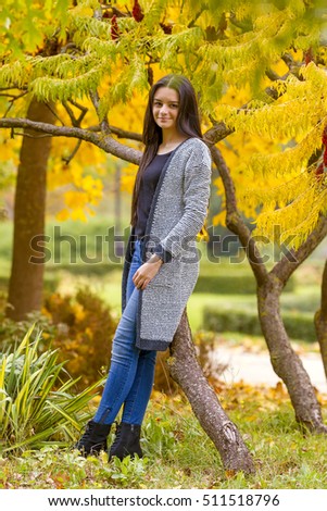 Portrait of pretty teen girl in autumn park. Smiling happy girl portrait, autumn outdoor.