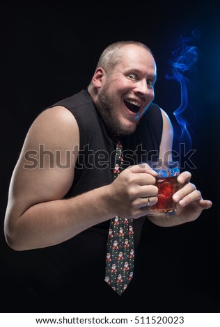 Comic actor funny man with a glass of hot drink on a black background, Christmas and New Year
