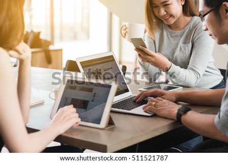Group of friends meeting in a coffee shop chatting to each other while using smartphone tablet and laptop, internet of things conceptual