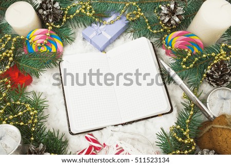 Christmas ornaments, fir branches and notebook with pen