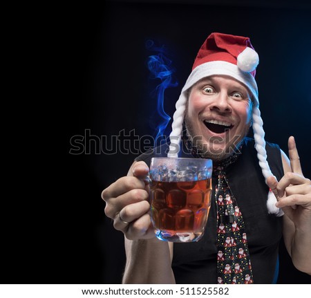 Comic actor funny man with a glass of hot drink on a black background, Christmas and New Year
