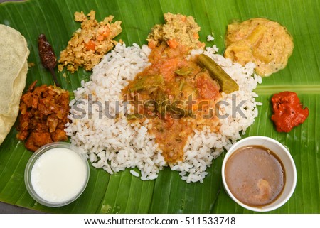 Vegetarian thali meals served on banana leaf, traditional south indian cuisine. Onam/vishu sadhya, boiled rice, served with curries Sambar, Rasam, Papadum, Payasam, Banana, Yogurt Kerala, chips