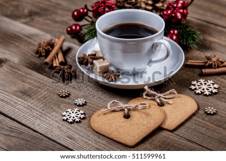 conceptual composition on a wooden table with a cup of coffee, ginger heart cookies and Christmas decorations. Happy new year background
