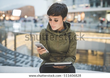 Half length of young handsome caucasian brown straight hair woman using smartphone and tablet, looking downward screen, smiling - multitasking, technology, social network concept concept Royalty-Free Stock Photo #511606828