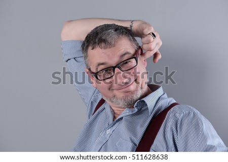Writer with glasses and suspenders is thinking about his work.