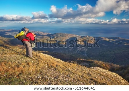 Photographer takes pictures on top of the mountain in autumn. Traveler with backpack enjoying a view from the mountain top

