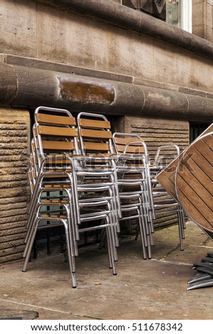 Chairs stacked outside a restaurant in an old city centre : Europe