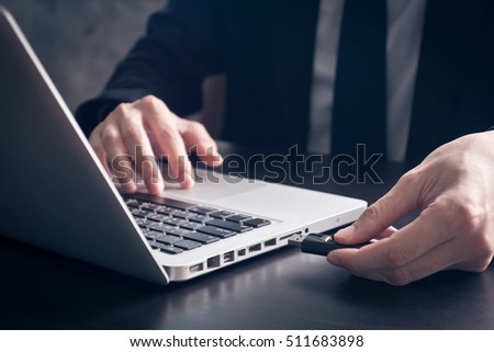 Close up of Businessman using flash drive connect to laptop on the office desk. Royalty-Free Stock Photo #511683898