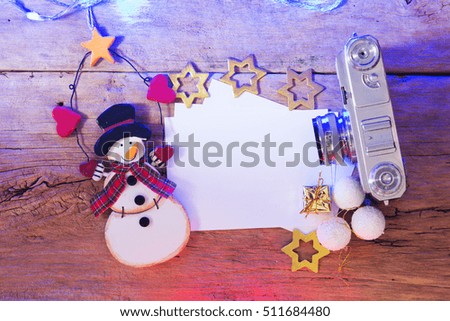 Christmas Decoration with Snowman and Old Photo Camera with Empty Space on Rustic Wooden Background. Image is Retro Filtered.