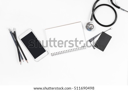 Doctor desk top view, shot from above of doctor table with notebook paper, pen, stethoscope flat lay display with copy space, top view photography project, medical doctor and healthcare concept.