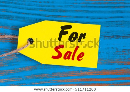 For Sale tag on blue wooden background. Sales, discount, advertising, marketing price tags clothes, furnishings, cars, food