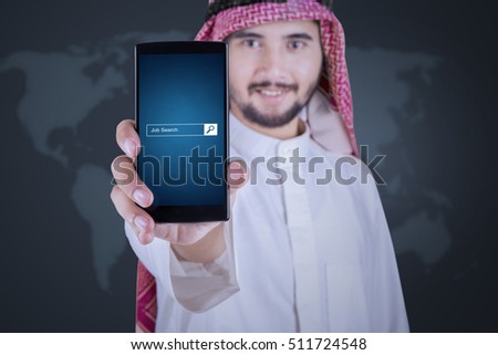 Image of Arabian businessman displaying a mobile phone with job search bar on the screen