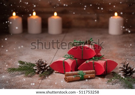 christmas gift boxes with spruce twigs, cinnamon, candles and cones on wooden top