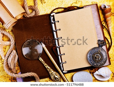old notebook, loupe and compass on the map