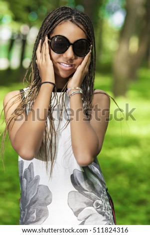 Portrait of Smiling African American Teenager With Long Dreadlocks. Posing in Green Forest Outdoors.Hands LIfted. Vertical Image