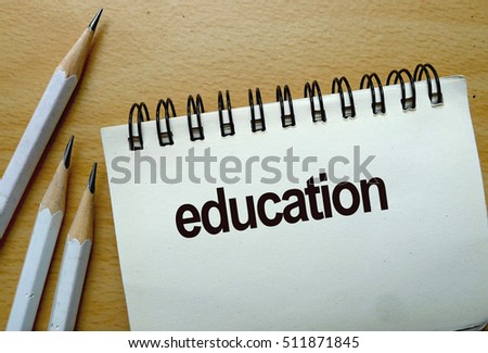 education text written on a notebook with pencils