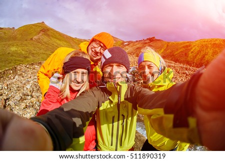Couple of friends tourists traveling on vacation, hiking in Iceland. smiling friends hugging and posing and taking selfie