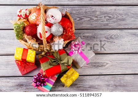 Bright Christmas balls and toy in a beautiful basket. Colorful Christmas presents are waiting for the new year. Cute New Year composition.